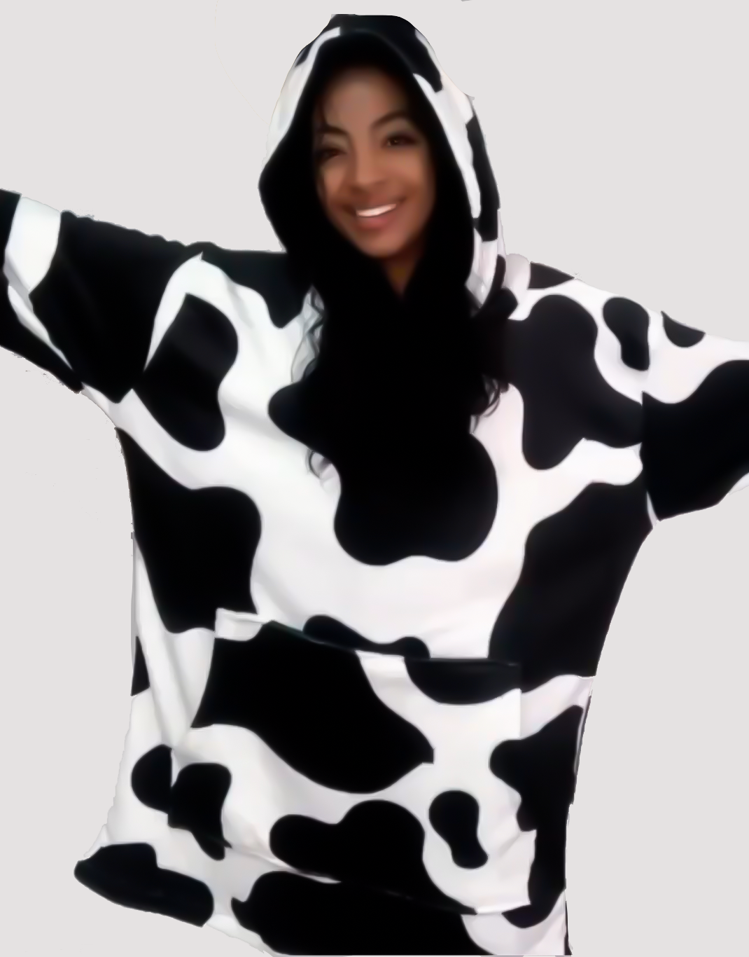 Mujer sonriendo con los brazos extendidos usando un saco gigante estampado de vaca
