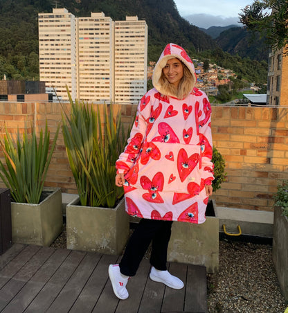 Mujer feliz usando un saco cobija con estampado de corazones en una terraza